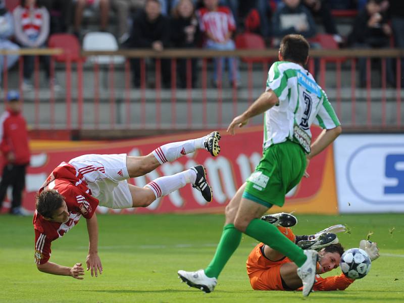 Brankář Bohemians Václav Winter likviduje šanci žižkovského útočníka Riste Naumova.