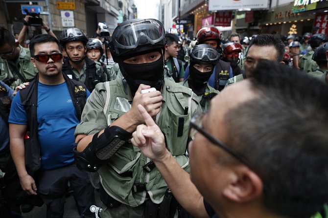 Demonstrant hovoří s policistou při protestech v Hongkongu