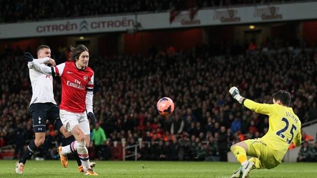 Tomáš Rosický z Arsenalu (uprostřed) překonává brankáře Tottenhamu Huga Llorise. 