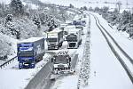 Sypač s radlicí odklízí sníh ze silnice 35 mezi Libercem a Turnovem, kde uvízly kamiony, 18. ledna 2023, Paceřice na Liberecku