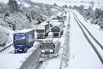 Sypač s radlicí odklízí sníh ze silnice I/35 mezi Libercem a Turnovem, kde uvázly kamiony, 18. ledna 2023, Paceřice na Liberecku.