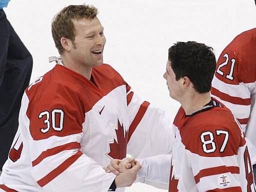 Gólman Kanady Martin Brodeur (vlevo) gratuluje střelci zlatého gólu na olympijských hrách Sidney Crosbymu.