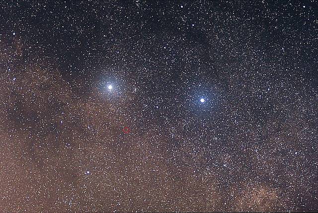 Dvě jasné hvězdy jsou Alfa Centauri (vlevo) a Beta Centauri, obě dvojhvězdy. Proxima Centauri je slabá rudá hvězda označená červeným kroužkem, v pravém úhlu k oběma a jihovýchodně od Alfy