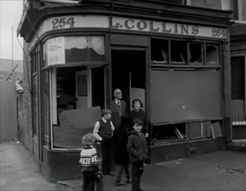 Irská rodina v Belfastu před zničeným obchodem