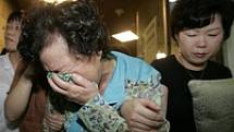 Matka a rodina uneseného devětadvacetiletého Šim Sung-mina pláče poté, co viděli televizní zpravodajství....