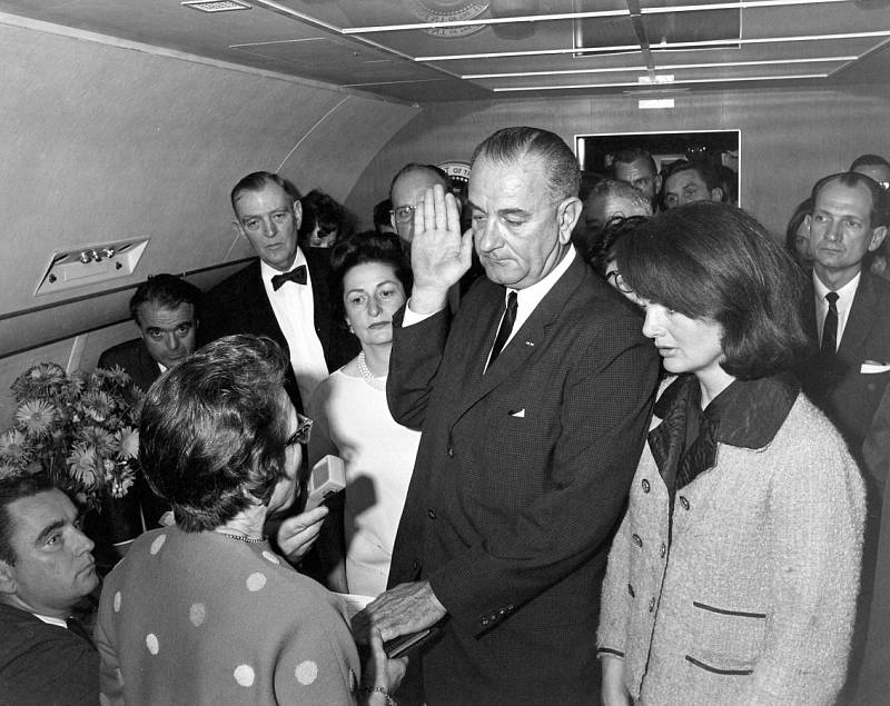 V AIR FORCE ONE.  L. B. Johnson přísahá 22. 11. 1963 při letu  z Dallasu nad  rakví zavražděného J. F. Kennedyho. 