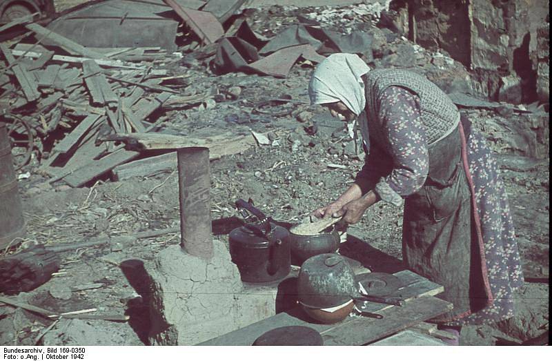 Jedna z obyvatelek Stalingradu se pokouší v troskách uvařit jídlo