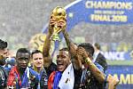 Fotbalista Francie Corentin Tolisso se raduje s trofejí pro mistry světa.