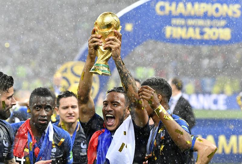 Fotbalista Francie Corentin Tolisso se raduje s trofejí pro mistry světa.