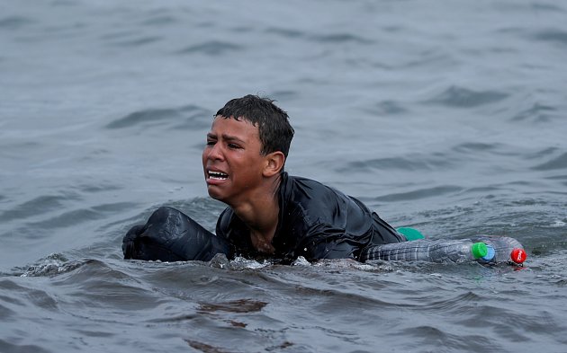 Plaváček, 19. května 2021. Šestnáctiletý Ašraf pláče vyčerpáním a prosí španělské vojáky na nedalekých člunech o pomoc. S plastovými lahvemi jako plovací vestou ho zachytil objektiv reportéra v moři poblíž plotu mezi španělsko-marockou hranicí u Ceuty