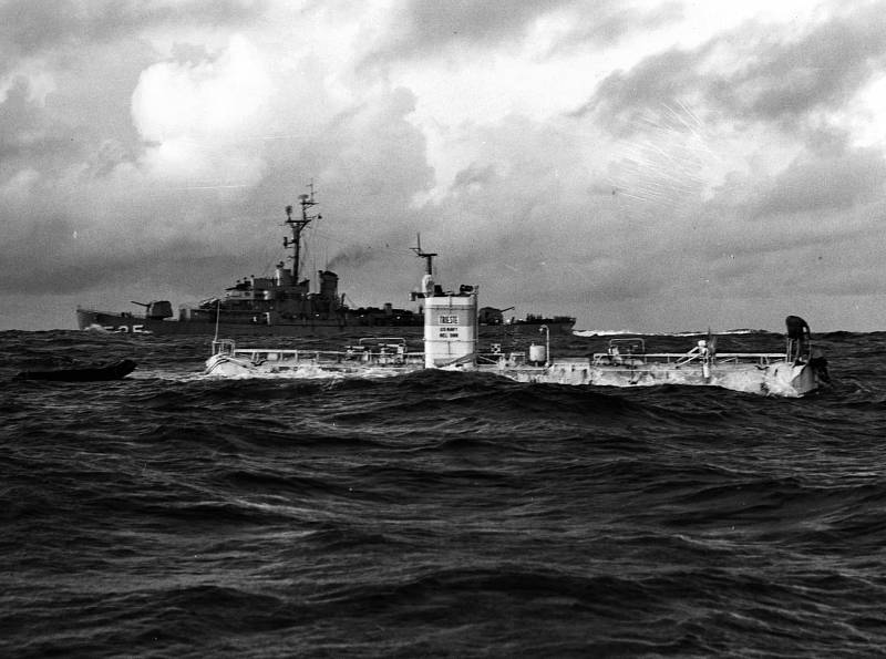 Batyskaf Trieste Trieste těsně před svým rekordním ponorem na dno Mariánského příkopu dne 23. ledna 1960. V pozadí proplouvá eskorta torpédoborců USS Lewis (DE-535)