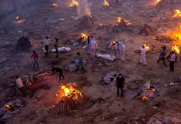 Ohně mrtvých, 23. dubna 2021. Lidé čekají na zpopelnění svých blízkých, kteří zemřeli v důsledku covidu, snímek je z tradičního otevřeného indického krematoriu v Novém Dillí