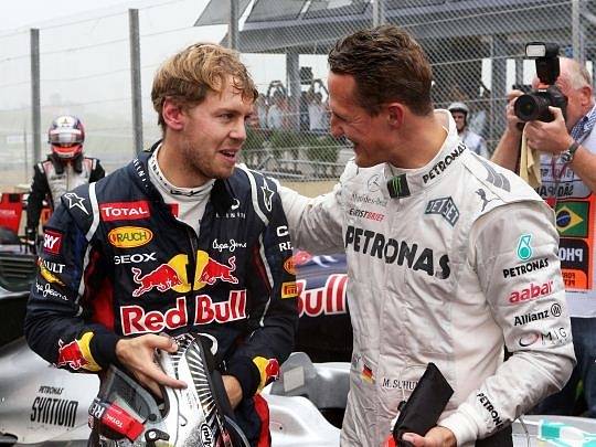 Sebastian Vettel přijímá gratulace od legendárního Michaela Schumachera.