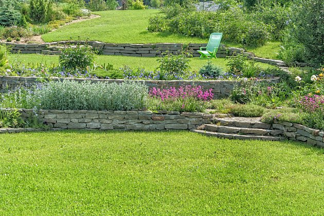 Kamenné zídky rozdělily zahradu na terasy.