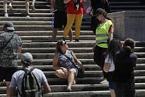 Policistka v Římě vysvětluje turistce, že sezení na Španělských schodech je zakázané.