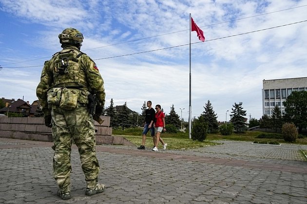 Ruský voják hlídkuje v ukrajinském Chersonu na snímku z 20. května 2022.