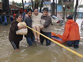 Sousedé pomájaí do bezpečí ženě v ničivými záplavami postiženém státe Tabasco. 
