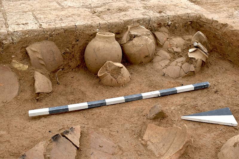 Keramické nádoby, v nichž byly uloženy klínopisné tabulky, stojí v rohu místnosti ze středoasyrského období.