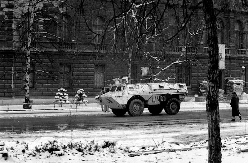 Obrněný transportér Spojených národů (UNPROFOR) míjí v zimě 1992-1993 prezidentský palác v Sarajevu