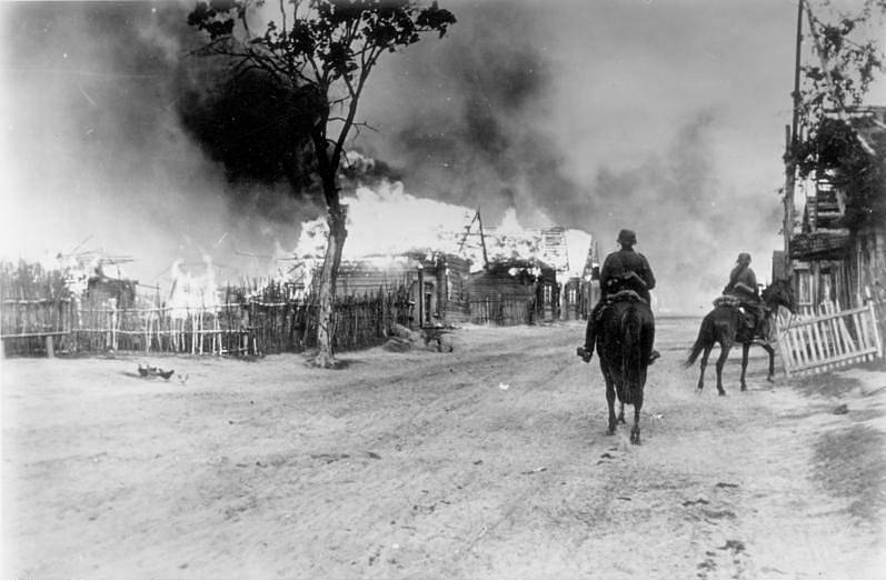 Německé jezdectvo projíždí hořící běloruskou vesnicí u Mogileva
