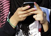 Dívka s mobilním telefonem v ruce - ilustrační foto