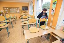 Žena dezinfikuje židli 15. října 2020 na základní škole npr. Eliáše v Pardubicích