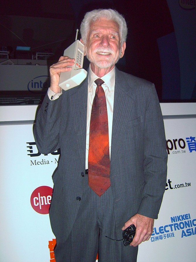 Otec mobilního telefonu Martin Cooper v roce 2007 s mobilem, ze kterého v roce 1973 uskutečnil vůbec první telefonát z takového přístroje.