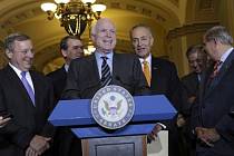Senátor John McCain (uprostřed) s kolegy u řečnického pultu poté, co byl schválen imigrační zákon.