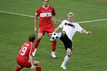 Němec Bastian Schweinsteiger (v bílém) se snaží zpracovat míč mezi dvojicí Turků Aythanem Akmanem a Gokhanem Zanem.
