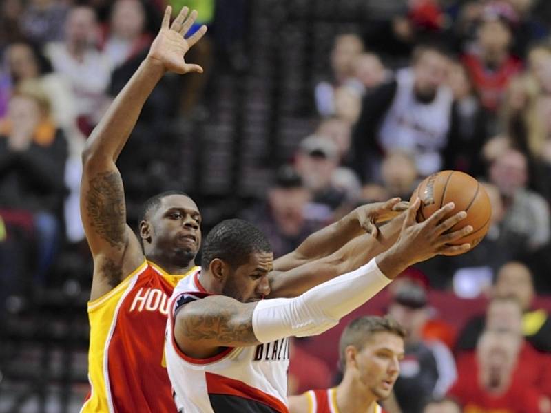 LaMarcus Aldridge z Portlandu (uprostřed) se snaží prosadit přes bránícího Terrence Jonese z Houstonu. 