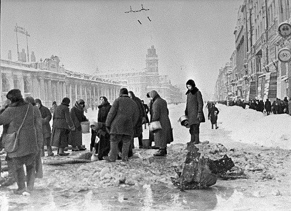 Obyvatelé obleženého Leningradu sbírají vodu, která po ostřelování natekla do kráterů v asfaltu na Něvském prospektu