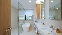 V prvním patře nechybí prostorná společná koupelna s velkou samostatně stojící vanou, pohodlným sprchovým koutem a umyvadly.