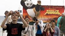 Turisté fotografují u reklamního panelu pro animovaný film "Kung Fu Panda"