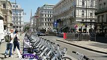 Sdílená kola a elektrokoloběžky jsou ve městě na každém rohu. Vídeň v letních vedrech.