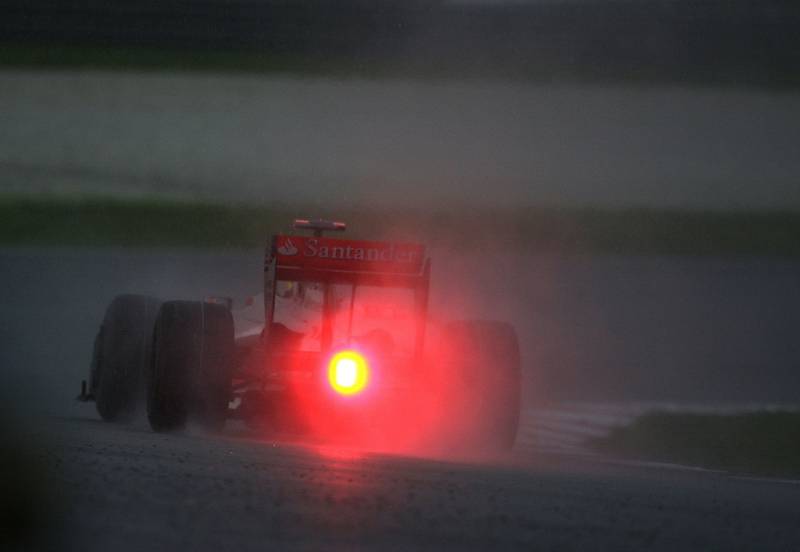 Lewis Hamilton řídí svůj McLaren v malajském lijáku.