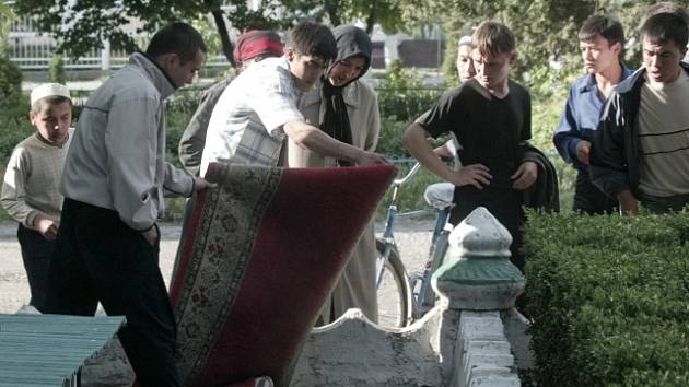 Lidé přikrývají mrtvolu v centru uzbeckého města Andižan.