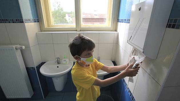 Žák v roušce 1. třídy ZŠ Komenského ve Světlé nad Sázavou si utírá ruce na toaletě do papírové utěrky (na snímku z 25. května 2020)