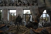 Ukrajinský voják v troskách budovy školy ve městě Lyman, 5. října 2022
