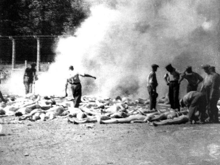 Členové sonderkommanda pálí v Osvětimi těla vězňů na venkovním ohništi poblíž krematoria V.