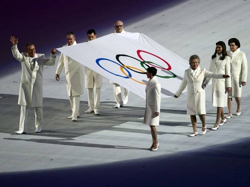 Významné osobnosti přináší olympijskou vlajku na stadion Fišt během slavnostního zahájení.