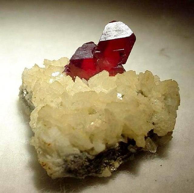 Přirozeně světlé, třešňově červené krystaly rumělky do 1,3 cm, posazené na kontrastní a krystalizované dolomitové matrici