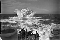 Několik mužů z posádky britského torpédoborce HMS Vanoc sleduje explozi hloubkových náloží, svržených v místě detekce ponorky.