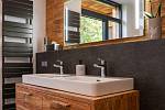 V nice nad vanou i na nábytku v koupelně je použito olivové dřevo.
