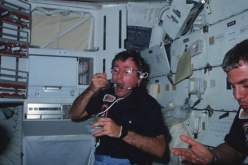 Velitel mise Apollo 16 John W. Young později v programu Space Shuttle pilotoval loď Columbia (na snímku obědvá na její palubě).