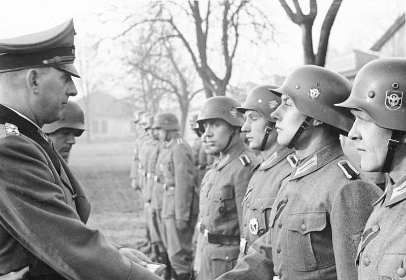 SS-Oberst-Gruppenführer Kurt Daluege vyznamenává důstojníky a muže policejního praporu „Cholm“, kteří patřili do Schererovy bojové skupiny, Cholmským štítem uděleným vůdcem