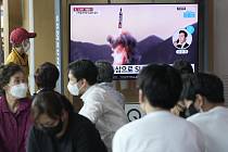 Lidé na vlakovém nádraží v jihokorejském Soulu sledují televizní reportáž o raketovém testu, který 7. května 2022 provedla KLDR.