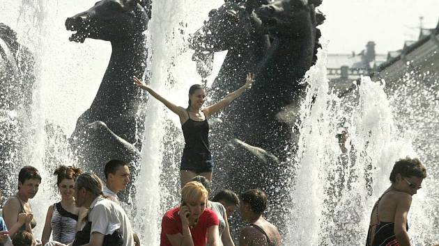 Lidé se chladí ve fontáně v moskevské Alexandrovské zahradě.
