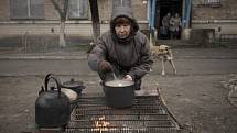 Žena vaří jídlo v Buči.