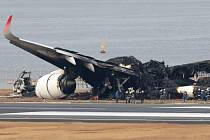 Na ranveji tokijského letiště hořelo letadlo. Na snímku jsou trosky uhašeného stroje.