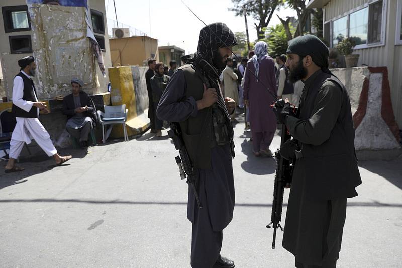 Ozbrojenci Tálibánu hlídkují před vstupem do prezidentského paláce v Kábulu